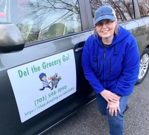 Del Lim posing next to her branded Del the Grocery Gal vehicle.