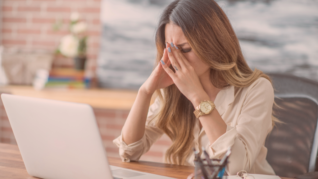 employee sad at laptop in need of managing workplace stress