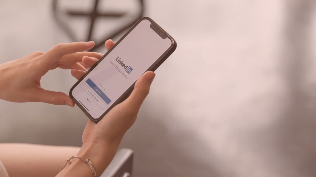 person updating their linkedin profile on their phone to make sure it matches their personal branding