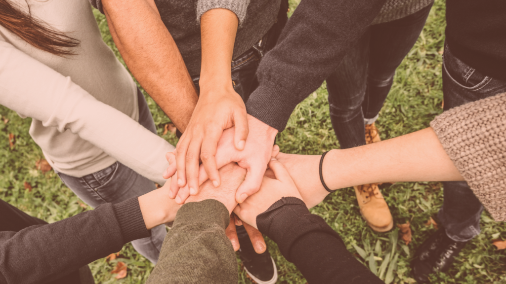 group of hands in before putting Volunteer Work on Resume